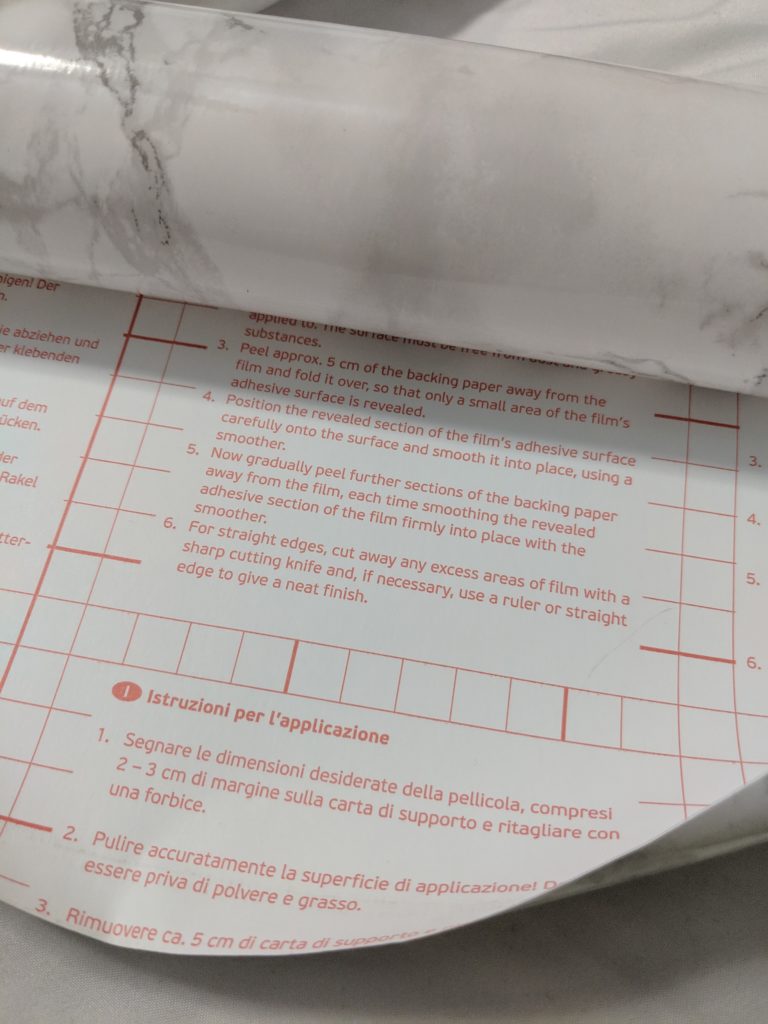 Decorative self adhesive film (contact paper) turned over displaying trimming guideline on the backing paper