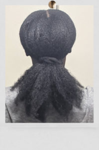 Rice water for natural hair challenge. Natural hair tied with a black scrunchie, showcasing results after the 90 days. Picture was taken of  heatless stretched 2 week old natural hair.
