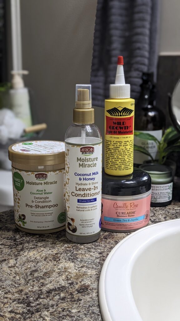 current wash day products; African pride pre shampoo, leave-in (spray), Camille rose curlaide moisture butter, and wild growth