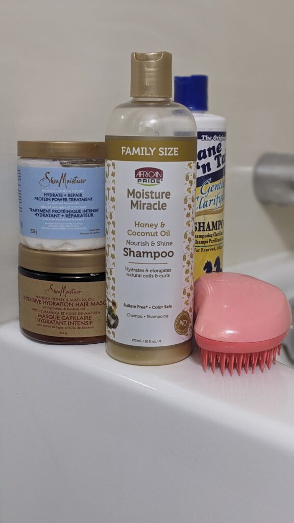current wash day hair products for the shower; sheamoisture protein treatment, Manuka honey and matura oil masque, and mane 'n tail gentle clarifying shampoo, 